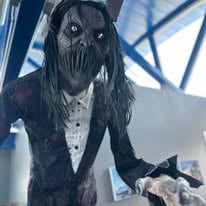 Tall masked figure in a suit at a past Haunted Tunnel
