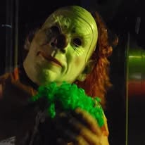 Masked clown holding green foam in the tunnel